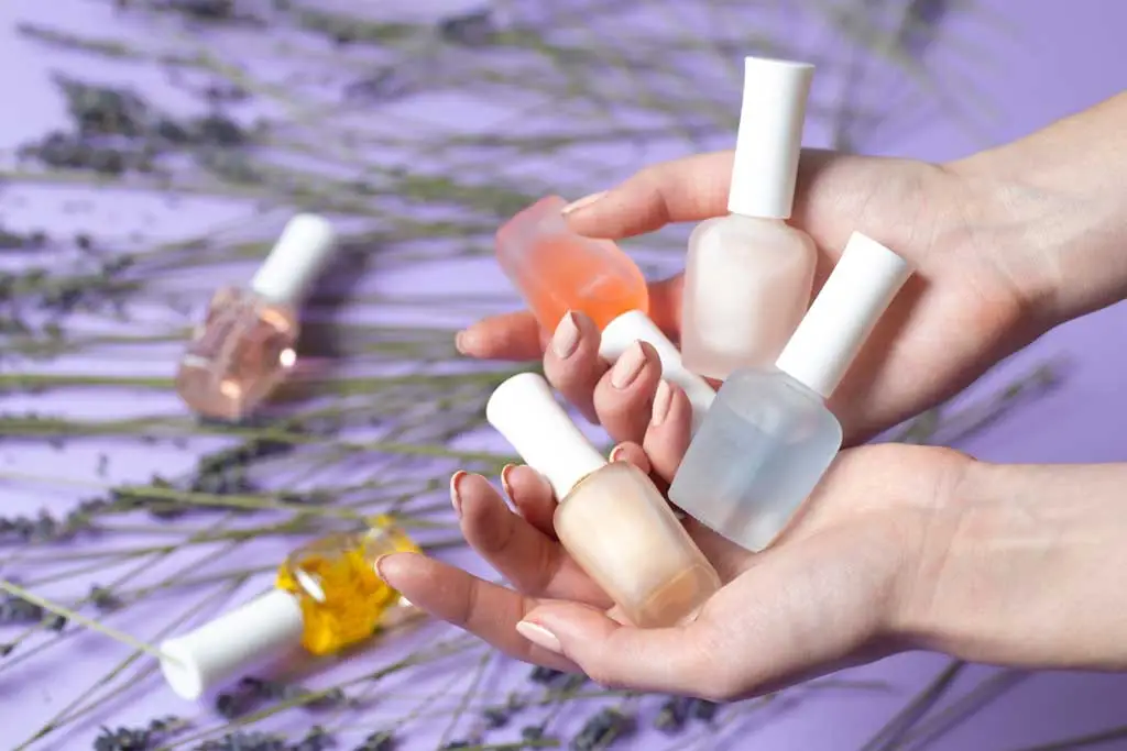 manicured hands holding nail treatments 1290039865