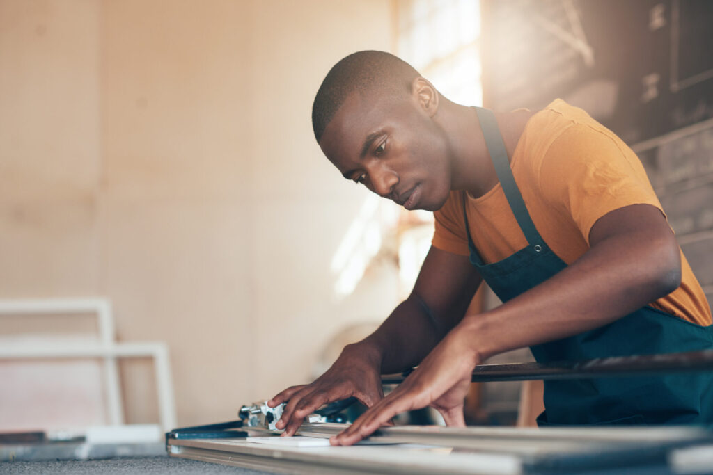 Skilled,Young,African,Craftsman,Working,In,Picture,Framing,Workshop