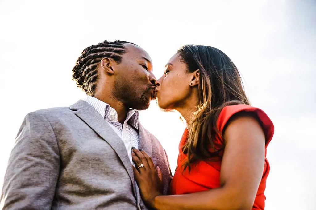 backlit portrait of couple kissing