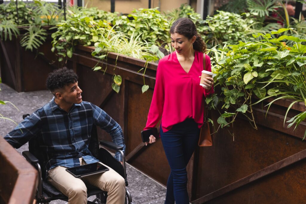 Happy,Diverse,Female,And,Male,Colleague,In,Wheelchair,Talking,In