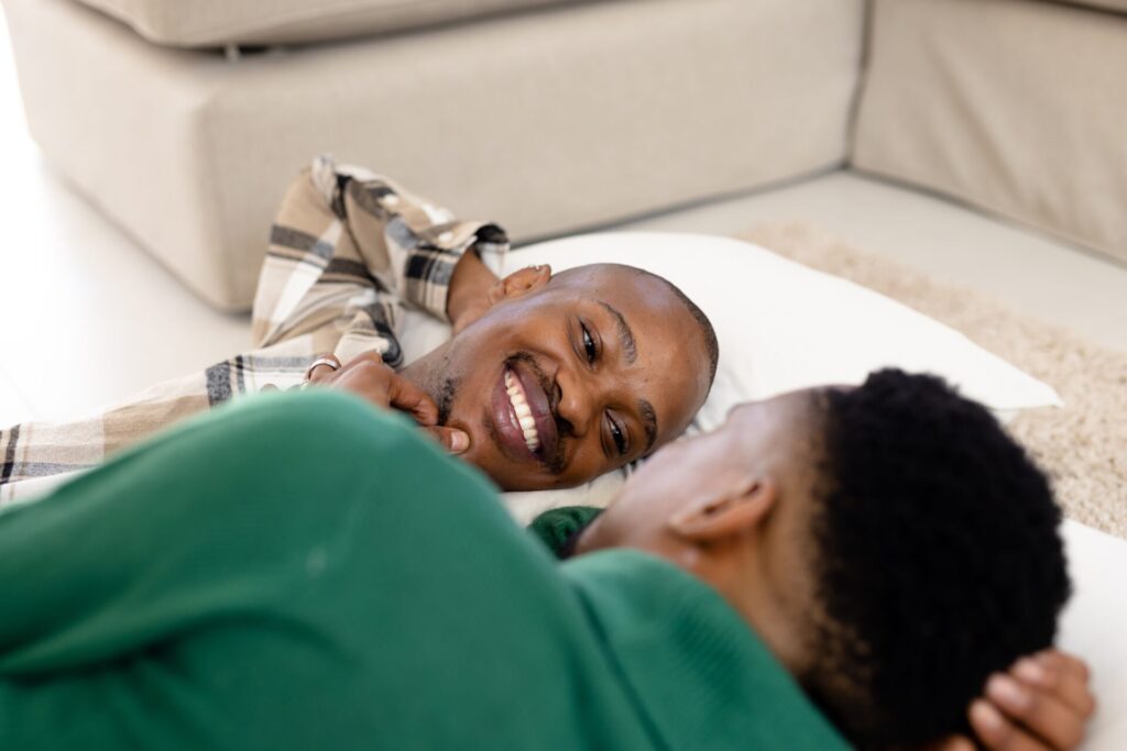 African,American,Young,Man,Touching,Smiling,Boyfriend's,Chin,While,Lying