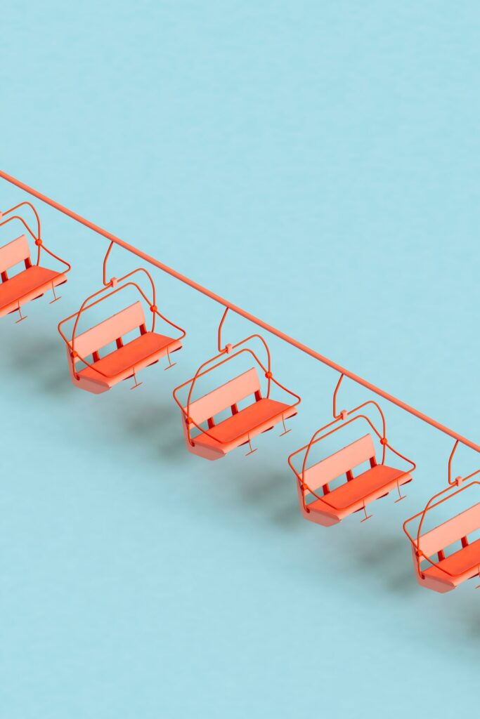 Three,Dimensional,Render,Of,Red,Ski,Lifts,Floating,Against,Blue