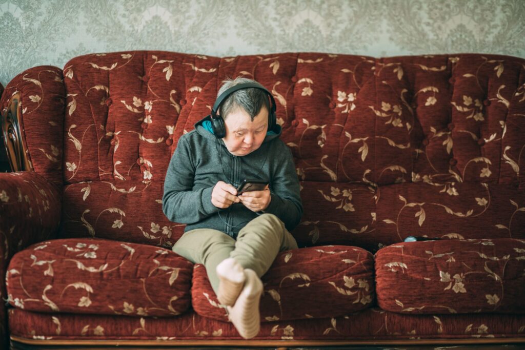 Elderly,Woman,With,Down,Syndrome,With,Smartphone,And,Headphones