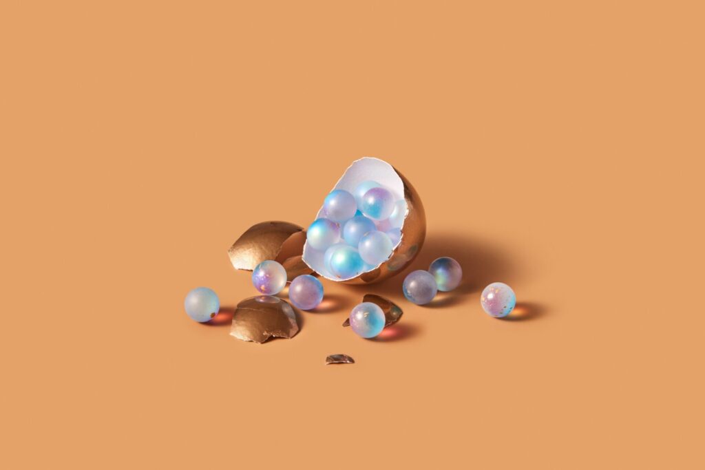 Delicate,Golden,Egg,Broken,With,Shiny,Pearls,Spilling,On,Warm toned