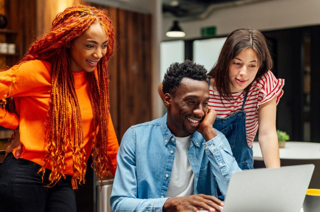 Multi ethnic,Business,Colleagues,Looking,At,Laptop,In,Office