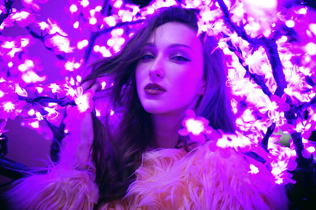 Sexy,Young,Beautiful,Woman,Posing,Near,Neon,Sakura,Tree,Lights