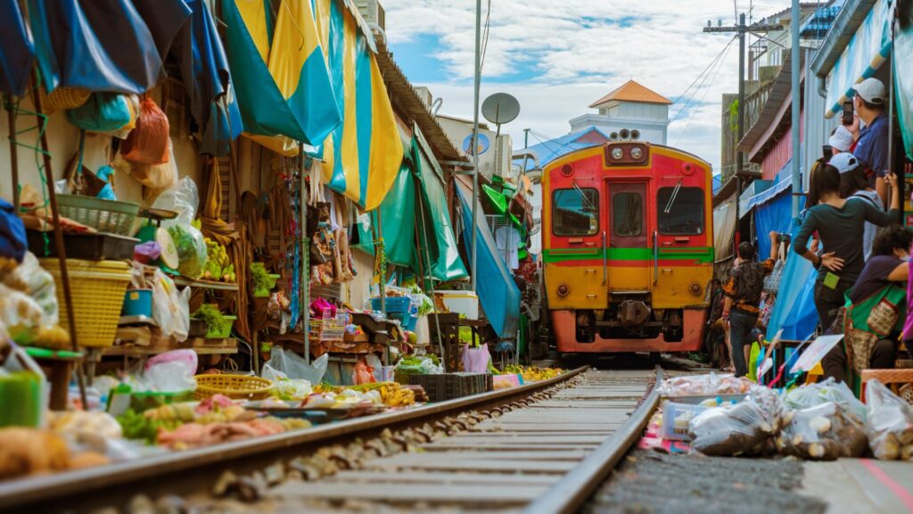 Maeklong,Railway,Market,Thailand,,Train,On,Tracks,Moving,Slow.,Umbrella