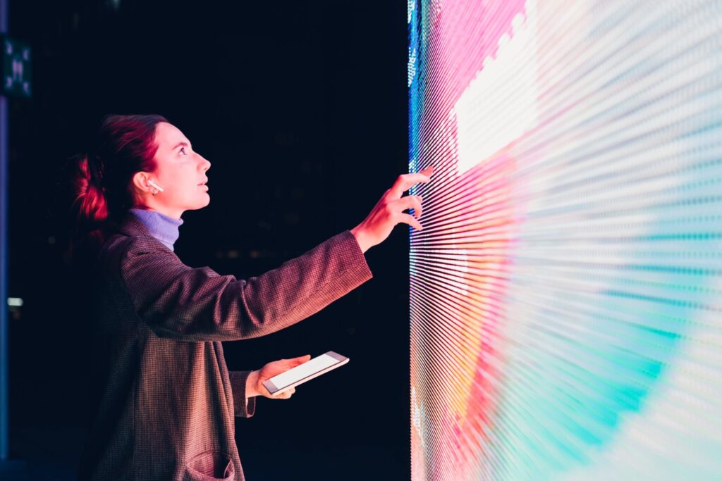 Businesswoman,Using,Touch,Screen,Interactive,Information,Booth,At,Night