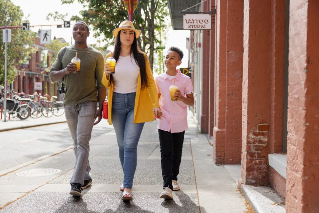 Multiracial,Family,Drinking,Bubble,Tea,,Walking,On,Sunny,Sidewalk